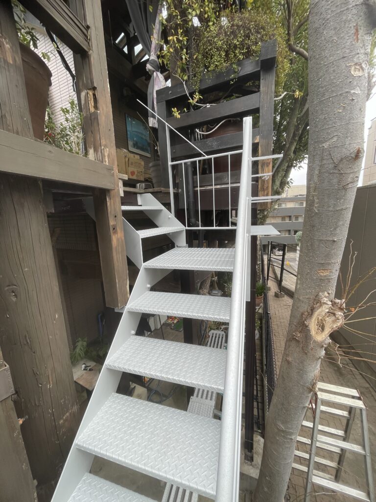 老朽化した木製外部階段を撤去し、縞鋼板とローバルシルバー仕上げの鉄骨階段へリノベーションした施工事例
